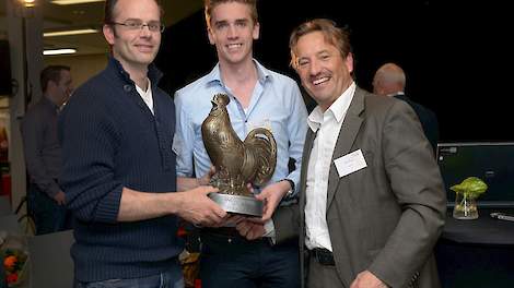 Rob Wingens (links) krijgt uit handen van Theo Hoen (rechts), algemeen directeur van Vencomatic, de wisselbokaal uitgereikt voor de winnende innovatie X-treck. Rob bedacht samen met zijn broer Egbert dat eieren ook in bestaande stallen moesten kunnen uitk