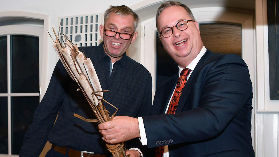 Piet Blanken overhandigt gedeputeerde Han Weber een bosje lisdodden