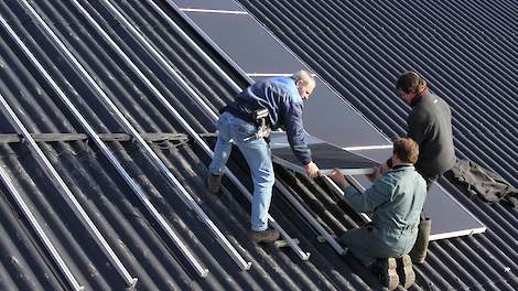 Plaatsen van zonnepanelen op een staldak.