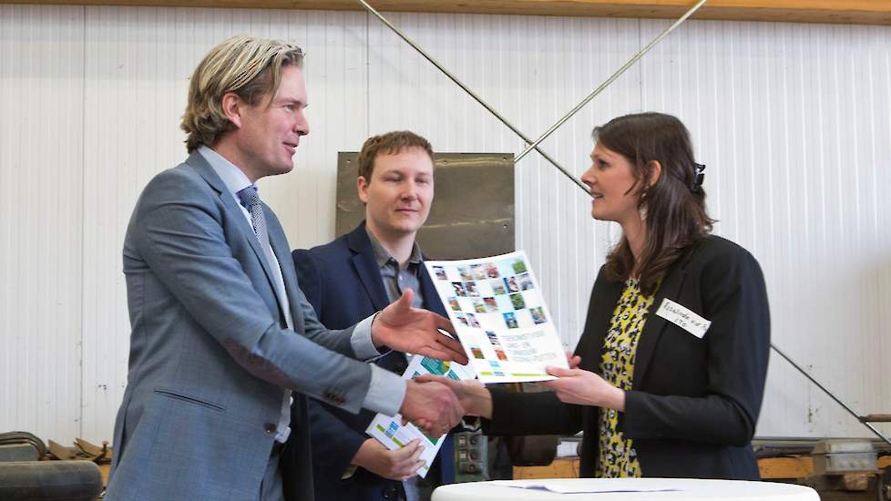 Rosalinda van der Poel overhandigt de Toekomstvisie Voorne-Putten aan burgemeester Foort van Oosten (links) en wethouder Igor Bal.