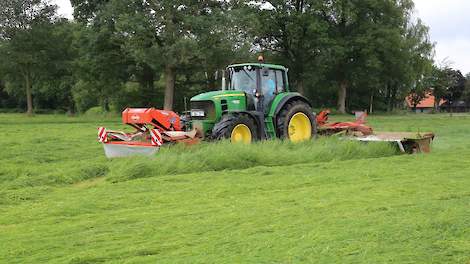 Grasland wordt gemaaid.