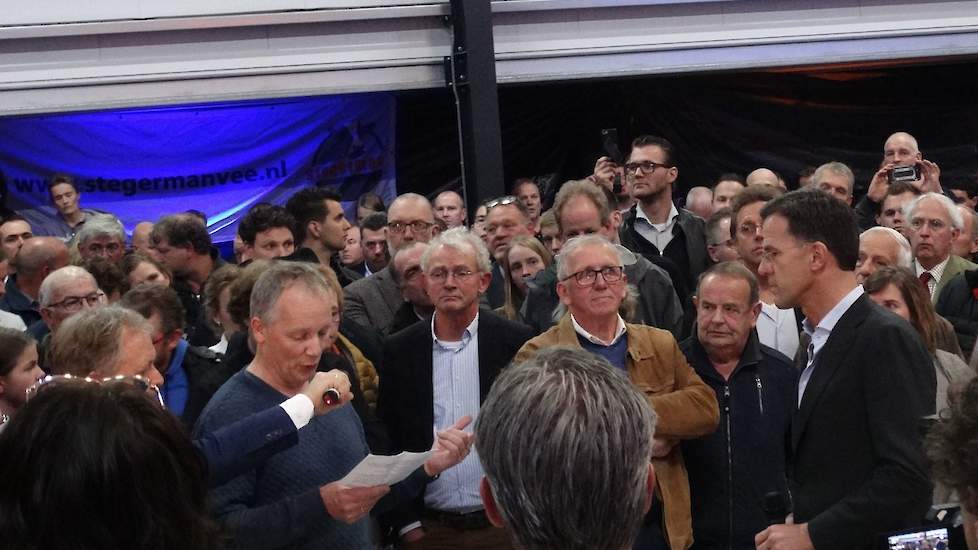 Varkenshouder Johnny Hogenkamp spreekt premier Mark Rutte toe tijdens een drukbezochte bijeenkomst van de VVD in Vinkenbuurt (OV).