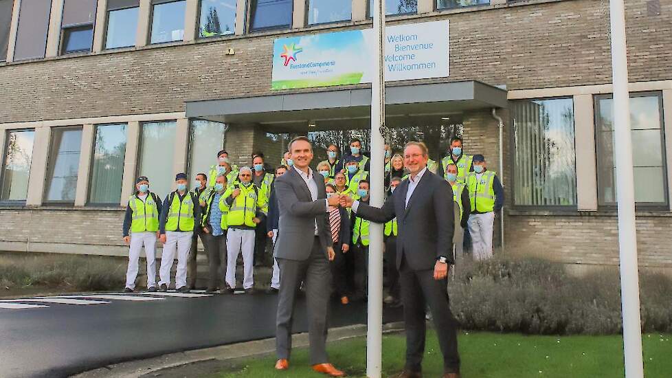 Arnoud van den Berg (President FrieslandCampina Trading) en Robert van Ballegooijen (COO Royal A-ware) hijsen de A-ware vlag op de plant in Aalter.