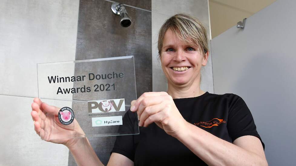 Carolien Hendrix-Laak houdt de douche award omhoog. „De prijs kwam als een verrassing.''