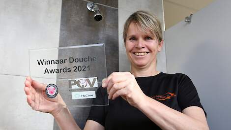 Carolien Hendrix-Laak houdt de douche award omhoog. „De prijs kwam als een verrassing.''