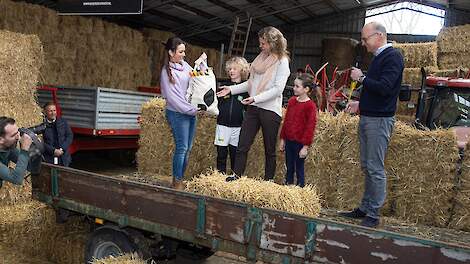Boerin Wendy van den Kieboom (L) overhandigt een tas met producten van BOER&NLekker aan de eerste klant mevrouw Annemiek Messer (40) met haar zoon Guus (7) en dochter Saar (9). Agrifirm-directeur Dick Hordijk (R) kijkt toe.