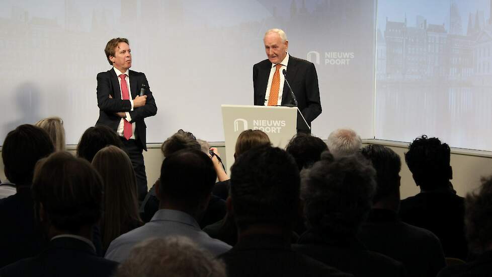 Remkes en zijn woordvoerder (links) presenteren het rapport aan de aanwezige pers.