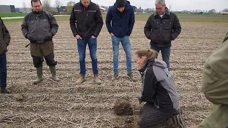 Anna Zwijnenburg bespreekt bodemprofiel met telers op het bedrijf van Dingeman Burgers.