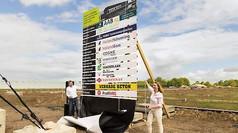 Allison Thomas, Chief Operations Officer en Dirk Neelis, Chief Financial Officer van Enza Zaden onthullen het bouwbord van de nieuwe biologische productielocatie in Luttelgeest.