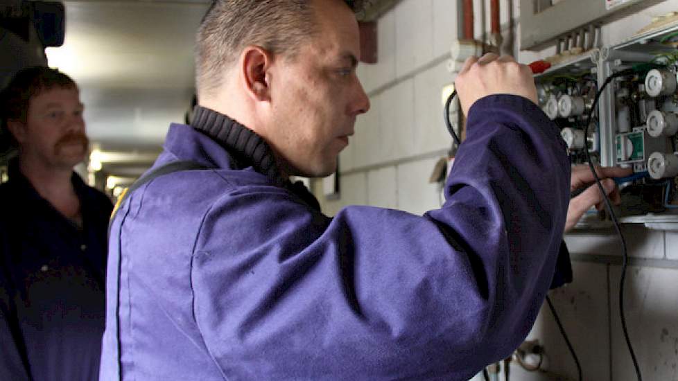 Karlo Rosing controleert een elektrische installatie in een varkensstal.