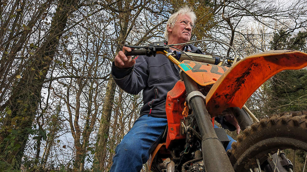 Op het weggetje langs zijn huis, waarover de crossers altijd naar het terrein liepen, poseert Dick Regelink met een door een maat zelf in elkaar gezette oude motor.