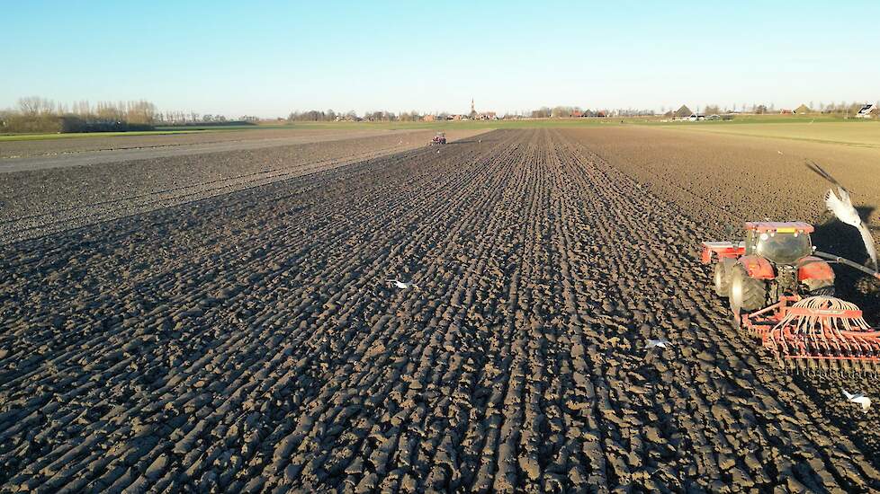 De trekkers met ploeg, spit-en zaaimachines reden af en aan door de polder.