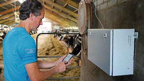 Met zijn telefoon kan melkveehouder Corné van Oosterhout de meetgegevens van de sensoren in zijn stal uitlezen.