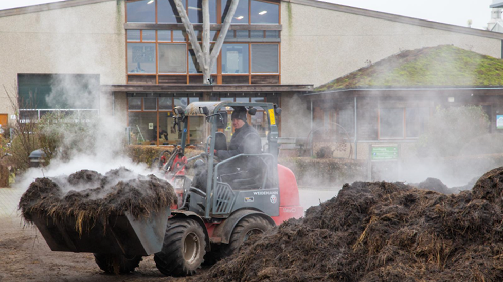 Het dampende zwarte goud, hier een mengsel van compost en bokashi, wordt de kas van het biologische glastuinbouwbedrijf BioVerbeek te Velden (LB) ingereden. Het markeert het begin van een nieuw groeiseizoen.