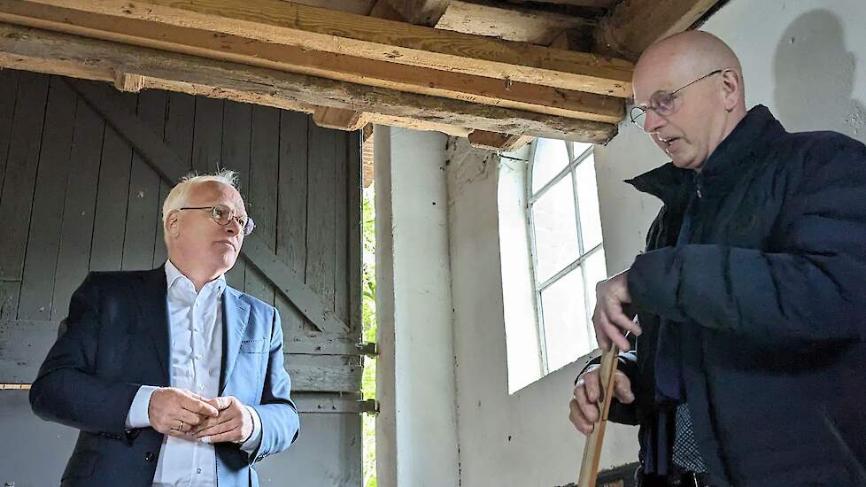 Piet Adema (links) onder het geheime luik van de boerderij in Lintelo (GD). Henk Ebbers gaf een rondleiding op de plek waar onderduikers zaten tijdens de Tweede Wereldoorlog.