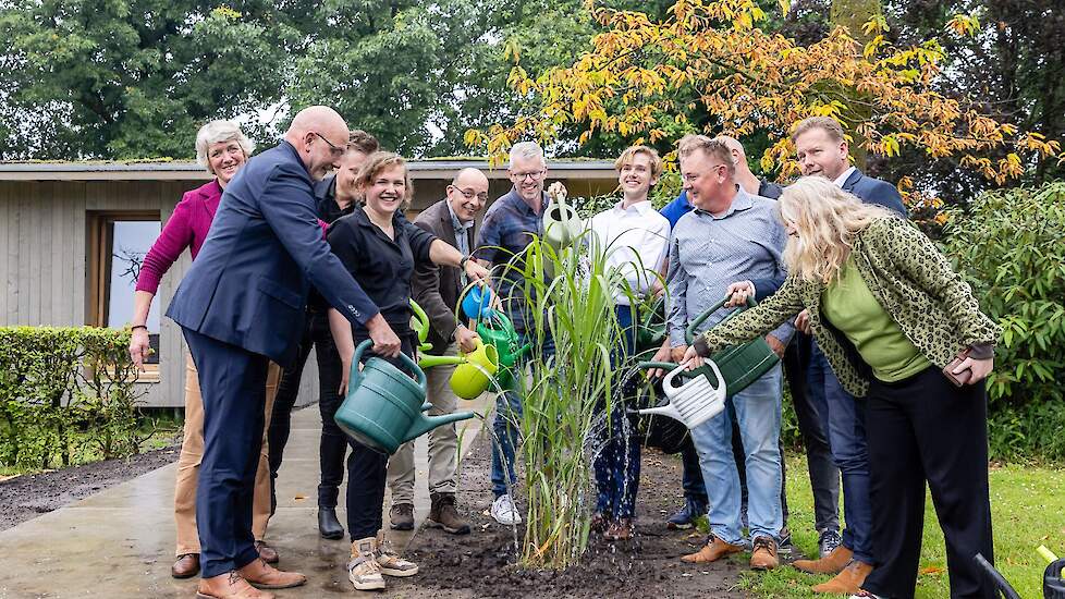 Fleur Brinke van Agro-innovatiecentrum De Marke en Mark Evers van Van Campen Bouwgroep, eigenaar van het paviljoen, planten een miscanthuspol als opening van het biobased paviljoen op de Marke.