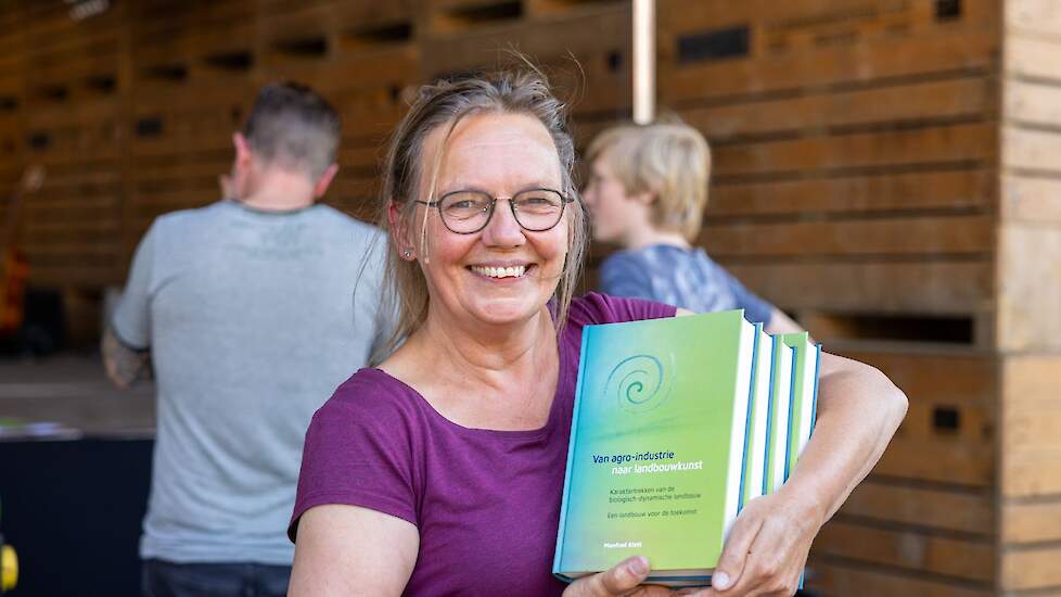 Tineke van den Berg met 'haar vertaling' tijdens de boekpresentatie op het Eeuwfeest op Warmonderhof