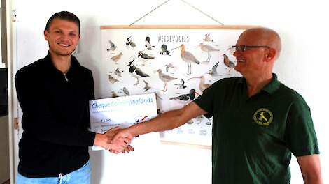 Voorzitter Hennie Schröder van de Vogelwerkgroep Geesteren krijgt van Rabobankmedewerker Jesse van Wijk een cheque van 5.000 euro.