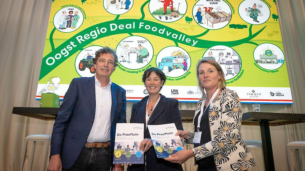 René Verhulst (links) overhandigt namens Regio Foodvalley de oogst van de Regio Deal aan het Rijk. In het midden Natalie Burgers, programmadirecteur Regio Deals VRO en rechts Marieke Mossink, Directeur Programmabureau LVVN.