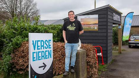 Frank Rooijakkers bij de eierautomaat op hun legpluimveebedrijf en woonadres.