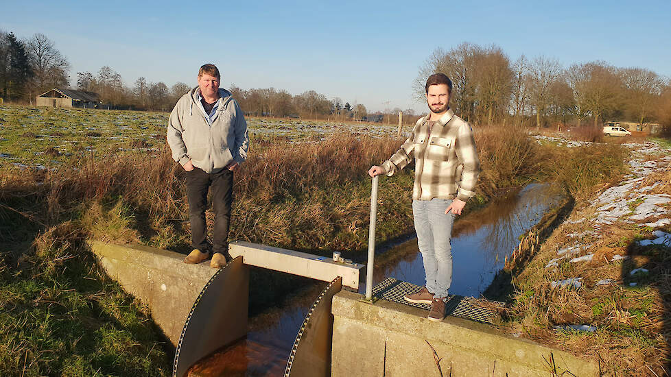 Pedro Vogels (links) en Geert van den Biggelaar bij een stuw in een waterschapssloot die ook in de laagste stand nog volop stroomt.