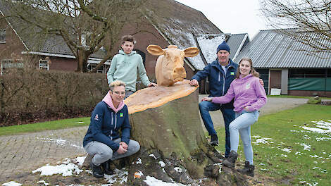 Angelique en Gert met hun beoogde opvolgers Jan en Esmeralda Zwambag bij het nieuwe boomkunstwerk voor de boerderij.