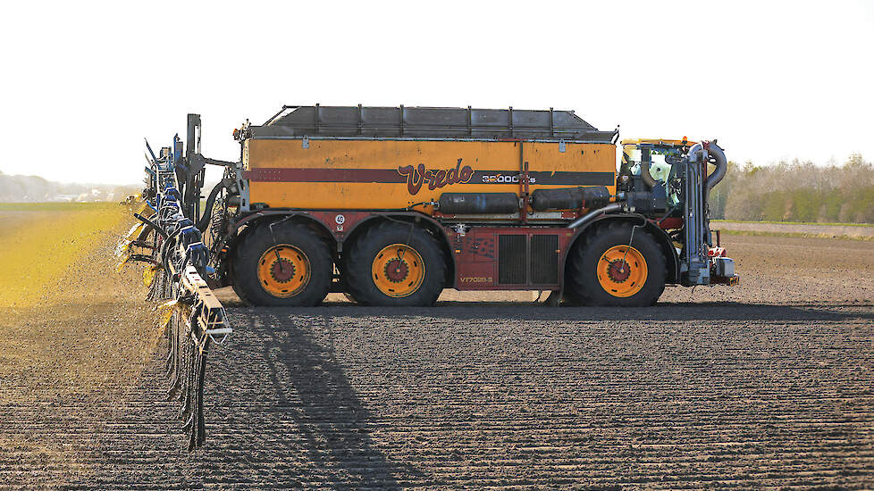 Chauffeur Arjan Veninga rijdt 12 kubieke meter rundveemest uit op een perceel uien om verstuiven van de jonge planten te voorkomen.