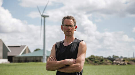 Marcel Brok voor de boerderij met een windmolen en 480 zonnepanelen.