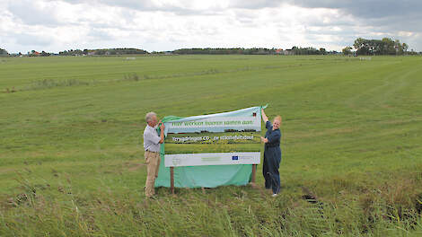 Frank de Wit, van Water, Land & Dijken, en gedeputeerde Rosan Kocken onthullen het projectbord, als symbolische start. „Ik vind het veelbelovend dat de boeren hiertoe zelf het initiatief nemen”, aldus Kocken.