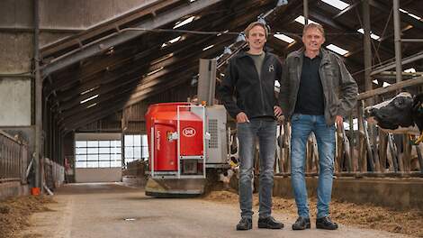 Familie Ruijter staat op de voergang voor de Lely Vector voerrobot. Dit automatische voersysteem voert meermaals per dag de koeien.