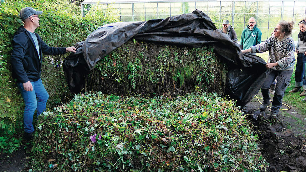Tuinder Esther Kuiler (rechts) dekt zorgvuldig de nieuwe bokashihoop toe met een zeil, voor zuurstofvrije fermentatie.
