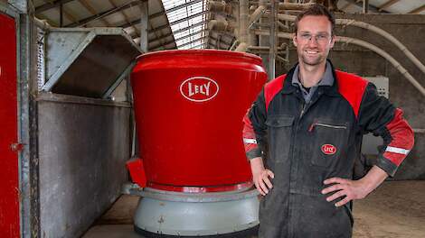 Melkveehouder die voor een Lely Vector automatisch voersysteem staat
