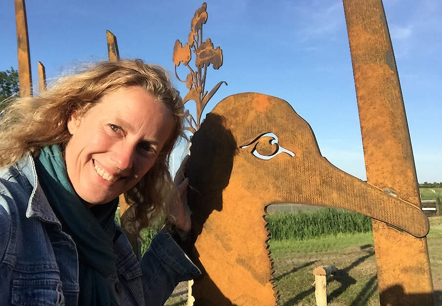 Barbe Messing legt beleefpaden aan. Hier staat ze bij een grote stalen weidevogel op Terschelling, een van haar creaties.