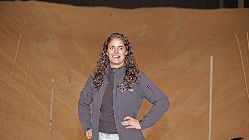 Thea Buseman bij een indrukwekkende bult opgeslagen graan in Scheemda.