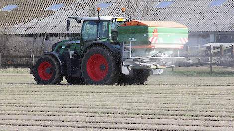 Trekker strooit kunstmest uit over akker