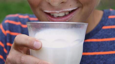 Kind drinkt melk met een melksnor.