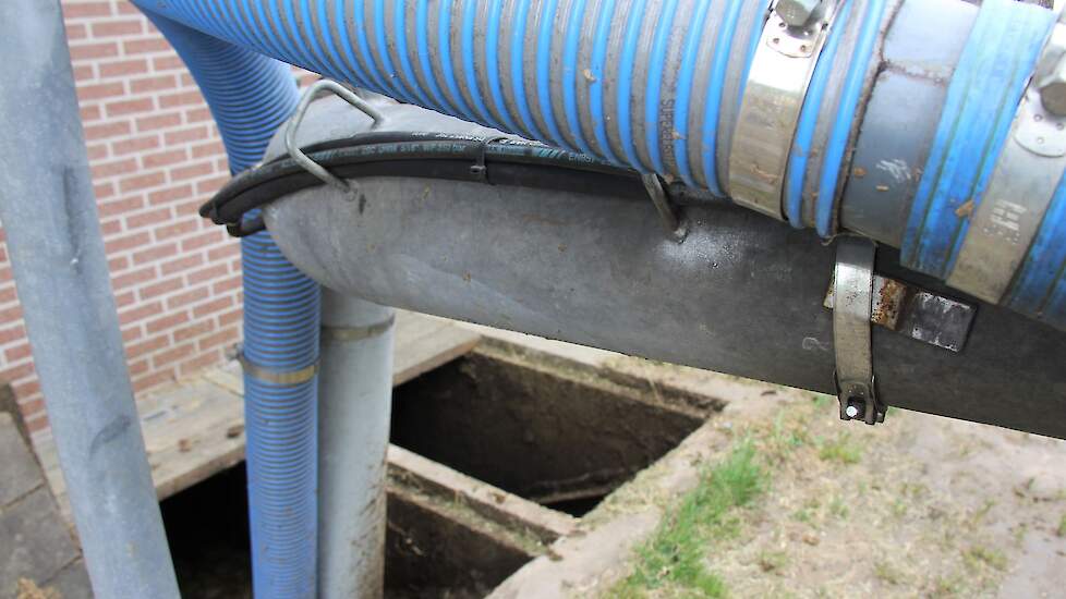 Met slangen wordt mest uit een kelder gezogen.