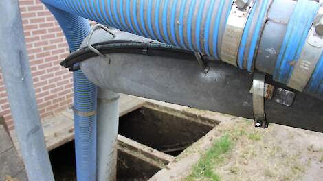 Met slangen wordt mest uit een kelder gezogen.