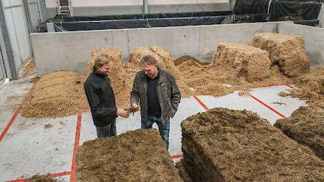 Veehouders die in een voerkeuken staan van een automatisch voersysteem