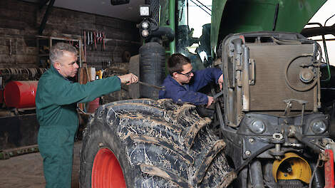 Medewerkers voeren onderhoud aan een trekker uit