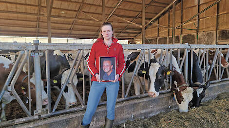 Angela Verhagen in de stal met in haar handen een ingelijste foto van Patrick Verhagen