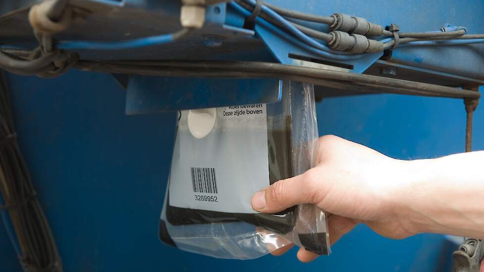 Een chauffeur neemt een monster uit een partij rundveedrijfmest.