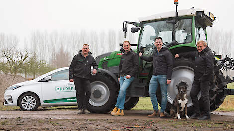 Jan-Willem Mulder, Martin Mulder, Jouke Dijkstra, Klaas Mulder en hond Tiko bij een elektrische trekker en dito bedrijfsauto van Mulder Loonbedrijf in Noorddijk.