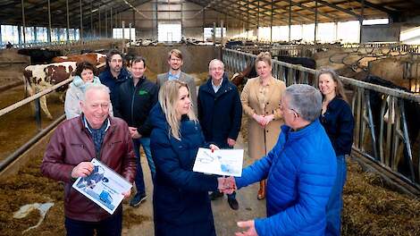 Minister Wiersma krijgt de gids voor transportwaardigheid van melkvee uitgereikt op een melkveebedrijf in Friesland.