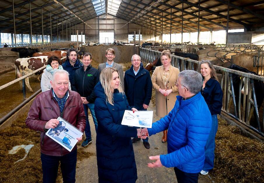 Minister Wiersma krijgt de gids voor transportwaardigheid van melkvee uitgereikt op een melkveebedrijf in Friesland.