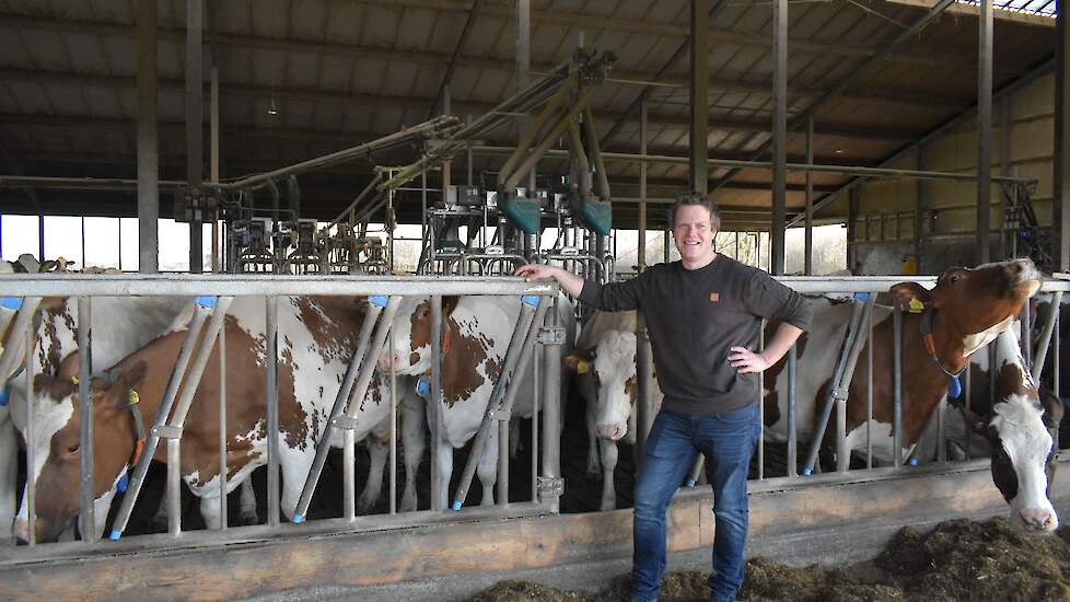 Melkveehouder Arfman bij koetoilet in stal