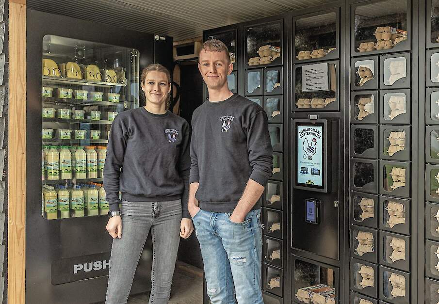 Jessica van Weperen en William van Rozen bij de verkoopautomaten, waar wekelijks zo&rsquo;n 10.000 eieren rechtstreeks aan klanten uit de regio worden verkocht.