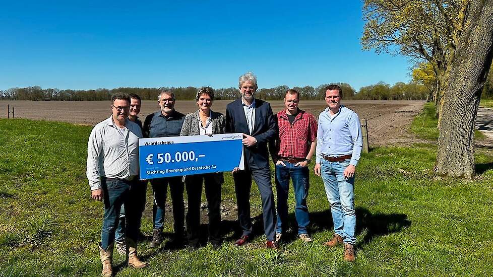 Gedeputeerden Willemien Meeuwissen en Henk Emmens overhandigen de cheque van 50.000 euro aan de stichting Boerengrond Drentsche Aa.