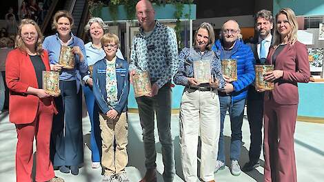 Bernd Hietberg samen met zijn zoon het midden, omringd door de Tweede Kamerleden.