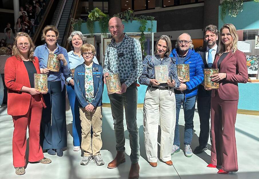 Bernd Hietberg samen met zijn zoon het midden, omringd door de Tweede Kamerleden.